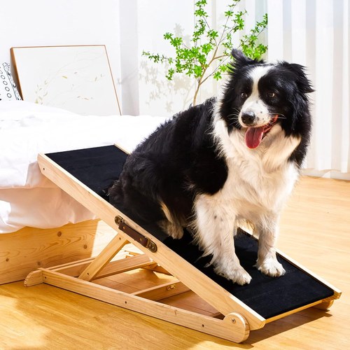 Woohoo adjustable wooden dog ramp with black non-slip surface set against a bed